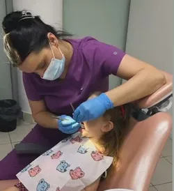 Objava na Instagramu: doktorka u ljubičastoj uniformi pregleda devojčicu